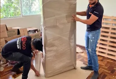 Profissionais protegendo um móvel antes do transporte